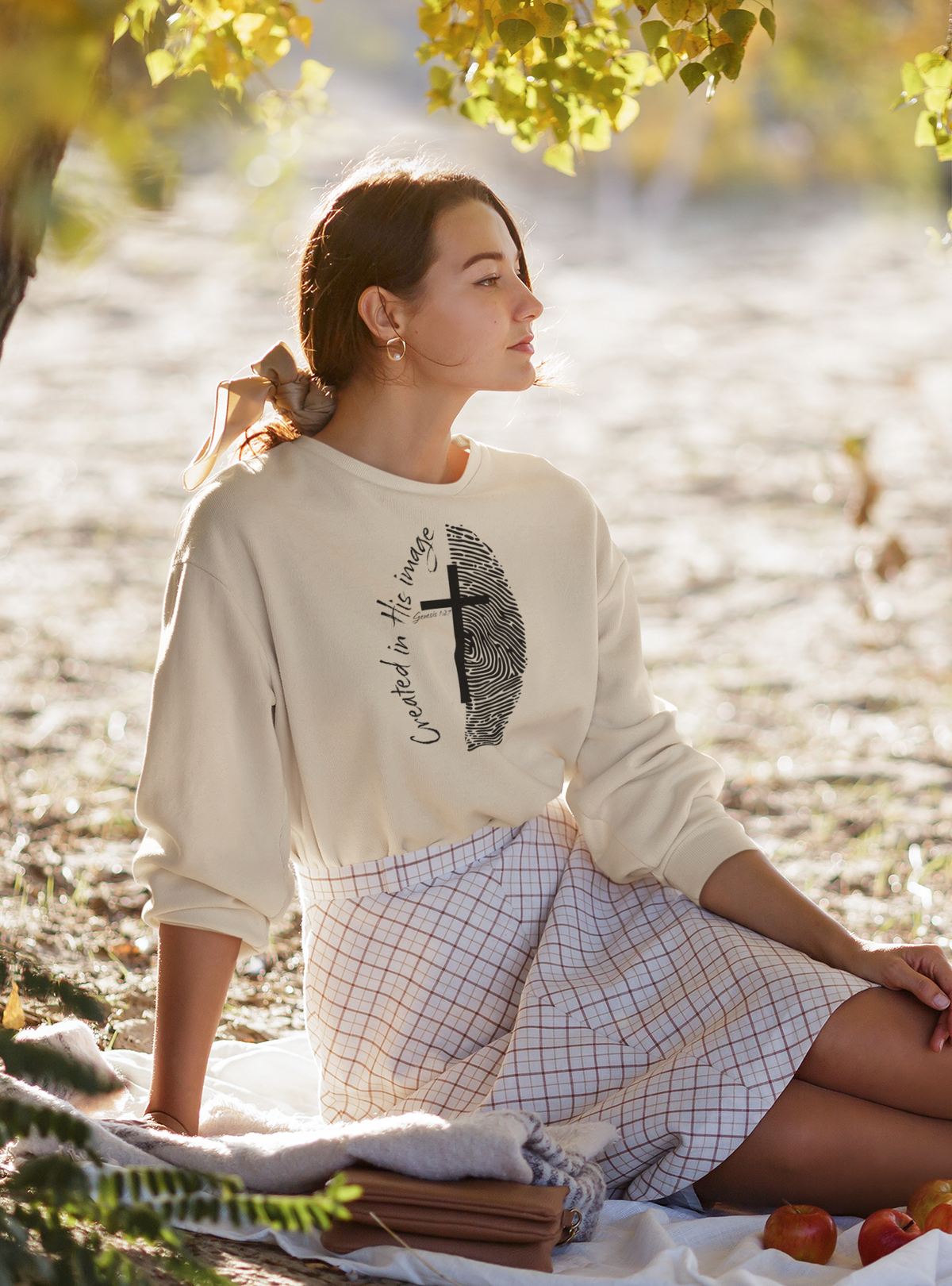 Women sitting in a created in His image crewneck sweater.