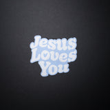 Blue Jesus Loves You Christian sticker with bubble letters on dark background