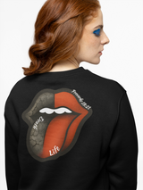 Person wearing a black sweatshirt with a graphic design on the back, featuring a stylized tongue and lips.