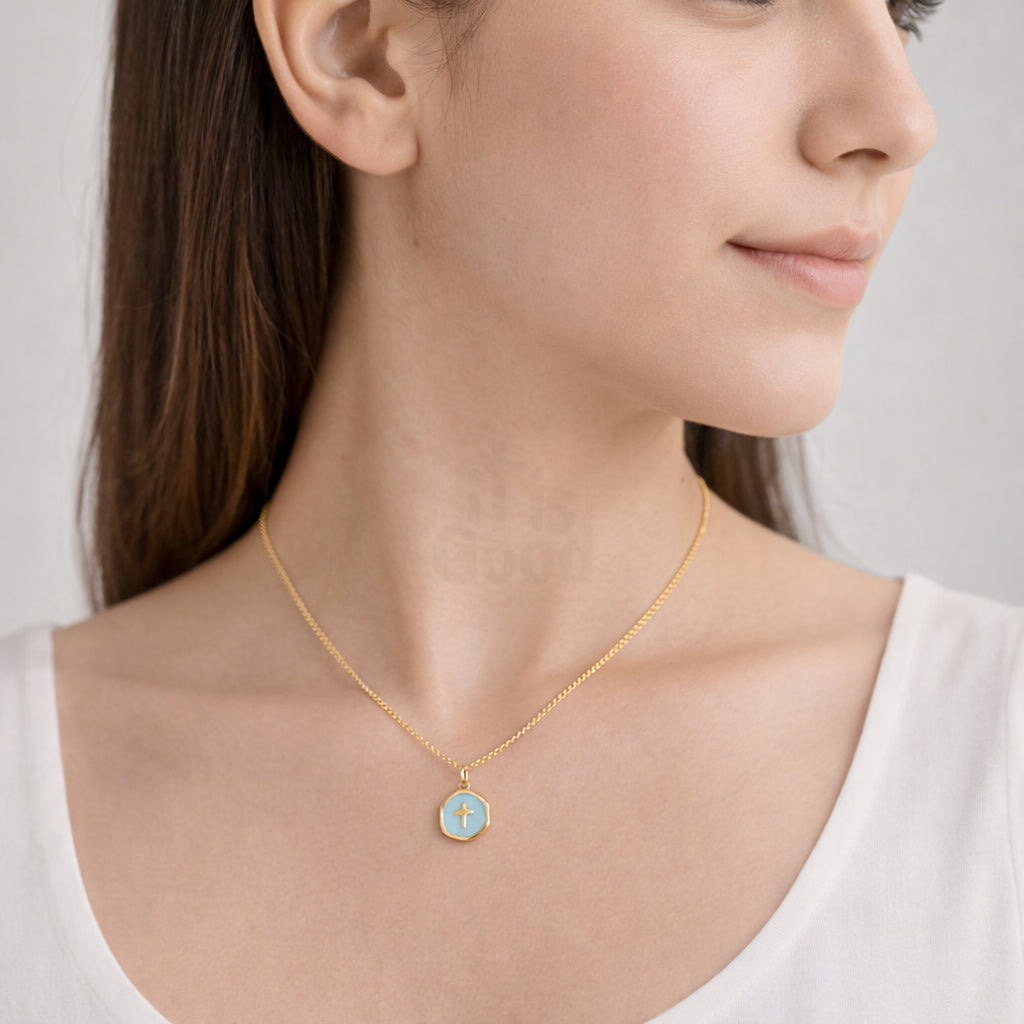 Close-up of a woman wearing a gold necklace with a blue pendant.