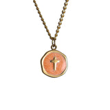 Gold chain necklace with round Orange pendant featuring a small cross at the center on a white background