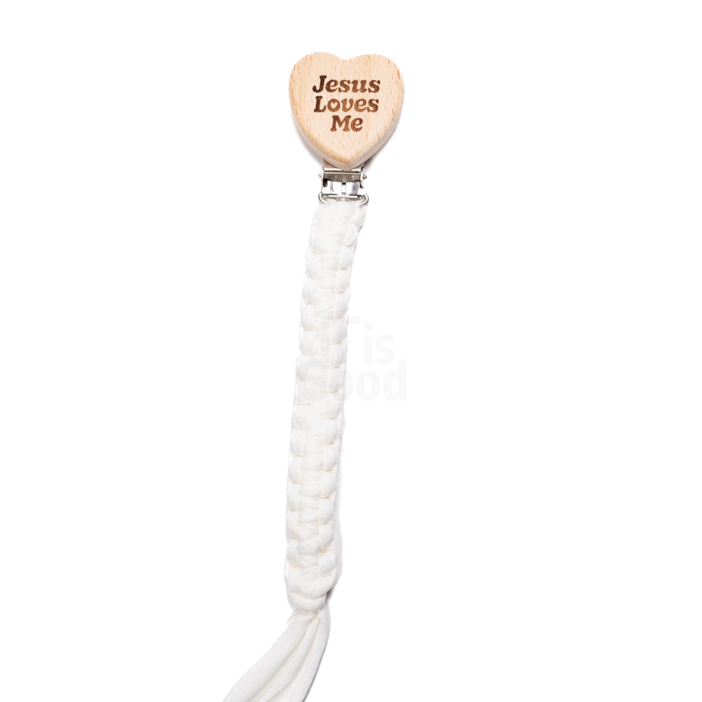 White braided baby pacifier clip featuring a wooden heart engraved with the words Jesus Loves Me, attached to a metal clip on a clean white background, designed for babies and toddlers