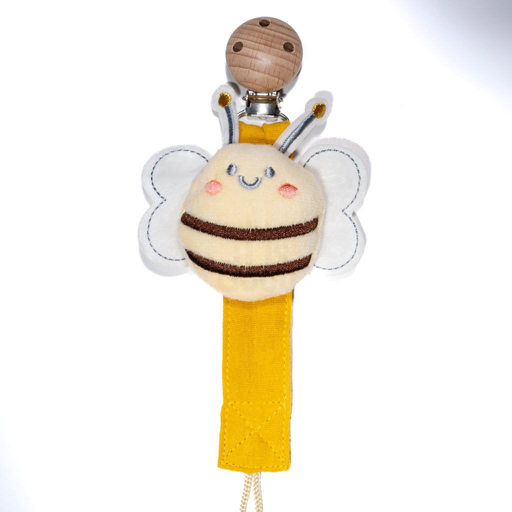Baby pacifier clip featuring a plush smiling bee with soft wings, a yellow fabric strap, and a wooden clip on a white background, designed for babies and toddlers