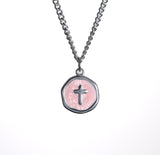 Necklace with a pink pendant featuring a cross on a white background