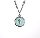 Necklace with a round pendant featuring a cross design on a white background