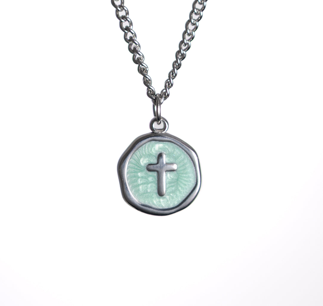 Necklace with a round pendant featuring a cross design on a white background