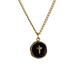Gold chain necklace with round Black pendant featuring a small cross at the center on a white background