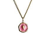 Gold chain necklace with round Hot Pink pendant featuring a small cross at the center on a white background