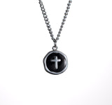 Necklace with a black pendant featuring a silver cross on a white background