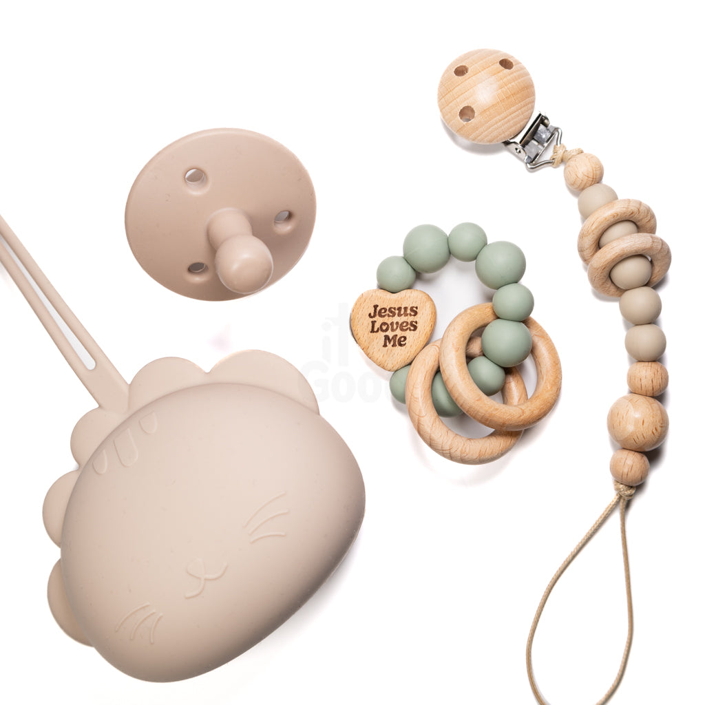 Collection of baby products including a silicone teether, wooden pacifier clip, and 'Jesus Loves Me' bracelet on a white background.