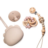 Baby teething products including a silicone pacifier, wooden teether, and pacifier clip on a white background.