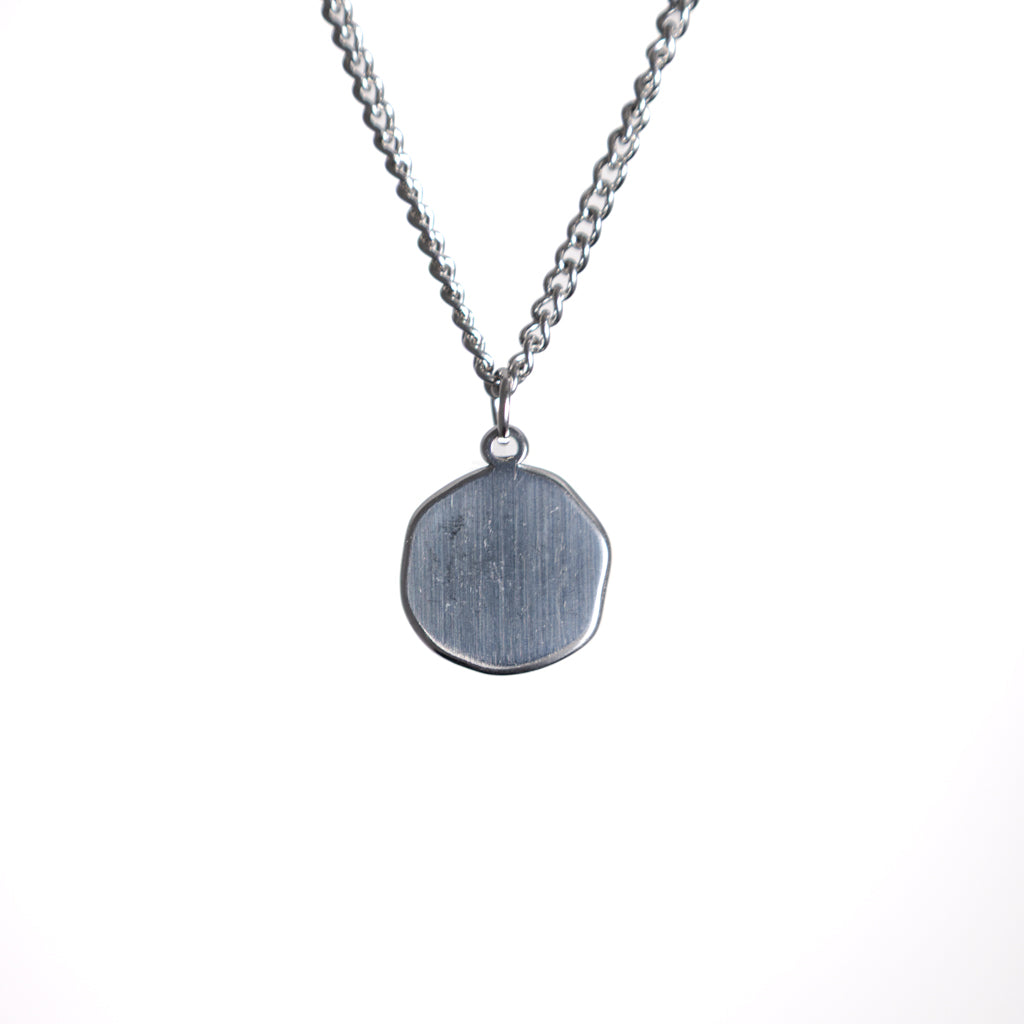 Silver necklace with a round pendant on a white background