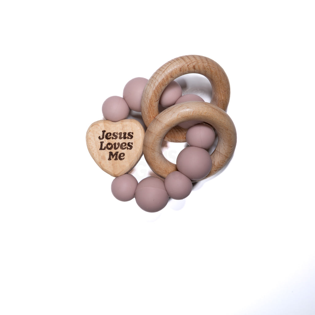 Wooden ring baby teether with mauve beads and engraved heart that says Jesus Loves Me